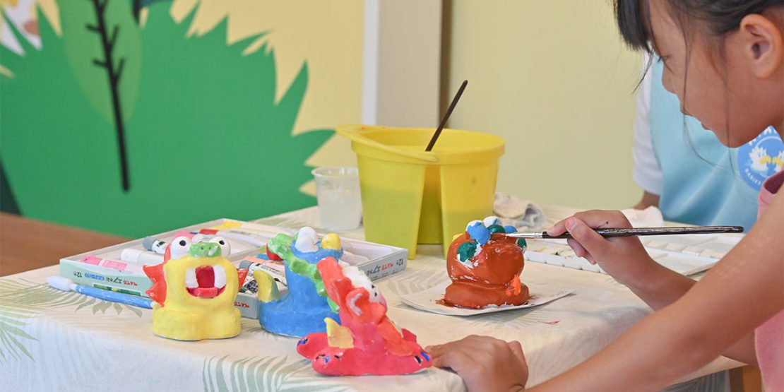 フサキビーチリゾートキッズプログラムのシーサー作りで色を塗る女の子