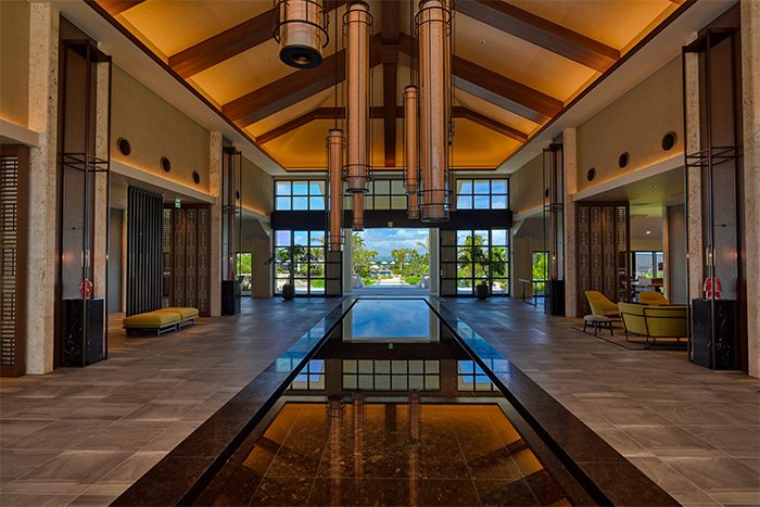 高い天井で開放感があるロビーの先にはプールと海が続く