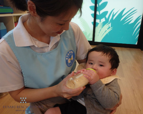 フサキの託児所でミルクを飲む男の子